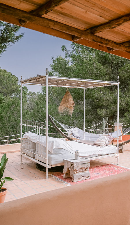A Mediterranean-style corner at Casa Naya Ibiza, featuring a rustic wooden console table, decorative baskets and tropical plants