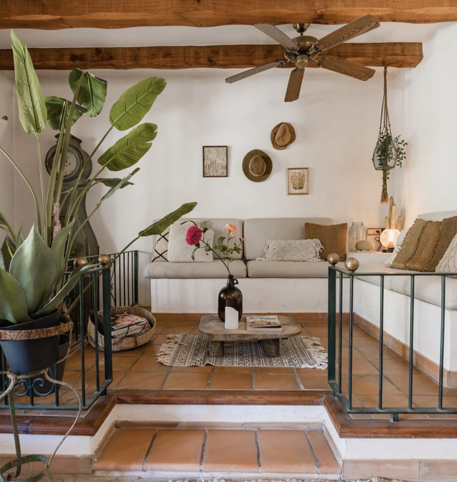 The cosy lounge at Casa Naya Ibiza, featuring wooden beams, boho-Mediterranean décor and tropical plants