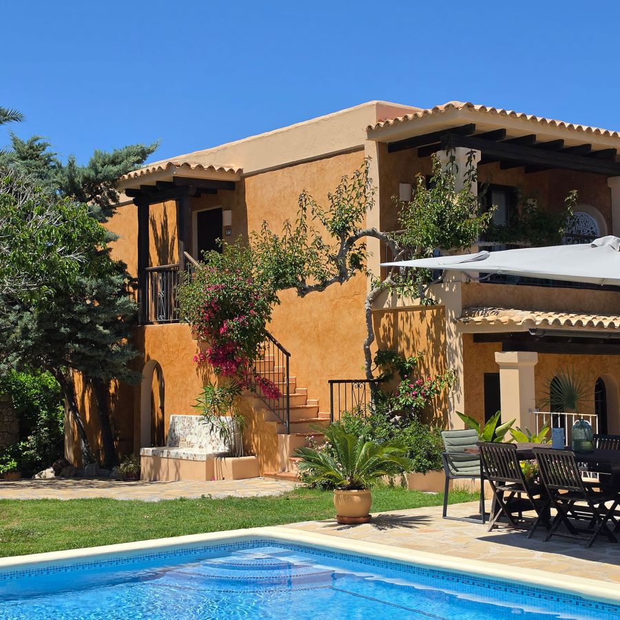Exterior view of Casa Naya Ibiza with a private pool, Mediterranean terraces and rustic architecture set amidst natural surroundings.